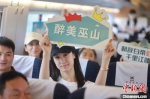 图为旅客举“醉美巫山”牌子庆祝郑渝高铁开通一周年。　苏志刚 摄 - 中国新闻社河南分社