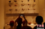　海外华裔青少年拍照记录馆藏彩陶碎片。　阚力 摄 - 中国新闻社河南分社