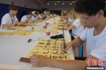 图为训练营成员围观教师创作书法作品。　韩章云 摄 - 中国新闻社河南分社
