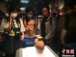 　今年7月，台胞青年在河南博物院欣赏馆藏仰韶时期彩陶。　中新社记者 阚力 摄 - 中国新闻社河南分社