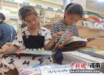 两位小朋友在长葛市新华书店阅读自己喜欢的图书。 左瑛君 摄 - 中国新闻社河南分社