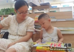 一位妈妈带着小宝宝在长葛市新华书店亲子阅读。 李春晓 摄 - 中国新闻社河南分社