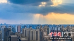 图为阳光透过云层射出一束束光柱。范晓恒 摄 - 中国新闻社河南分社
