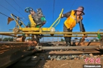 图为铁路职工利用道岔打磨机对钢轨肥边进行打磨修理。张中海 摄 - 中国新闻社河南分社